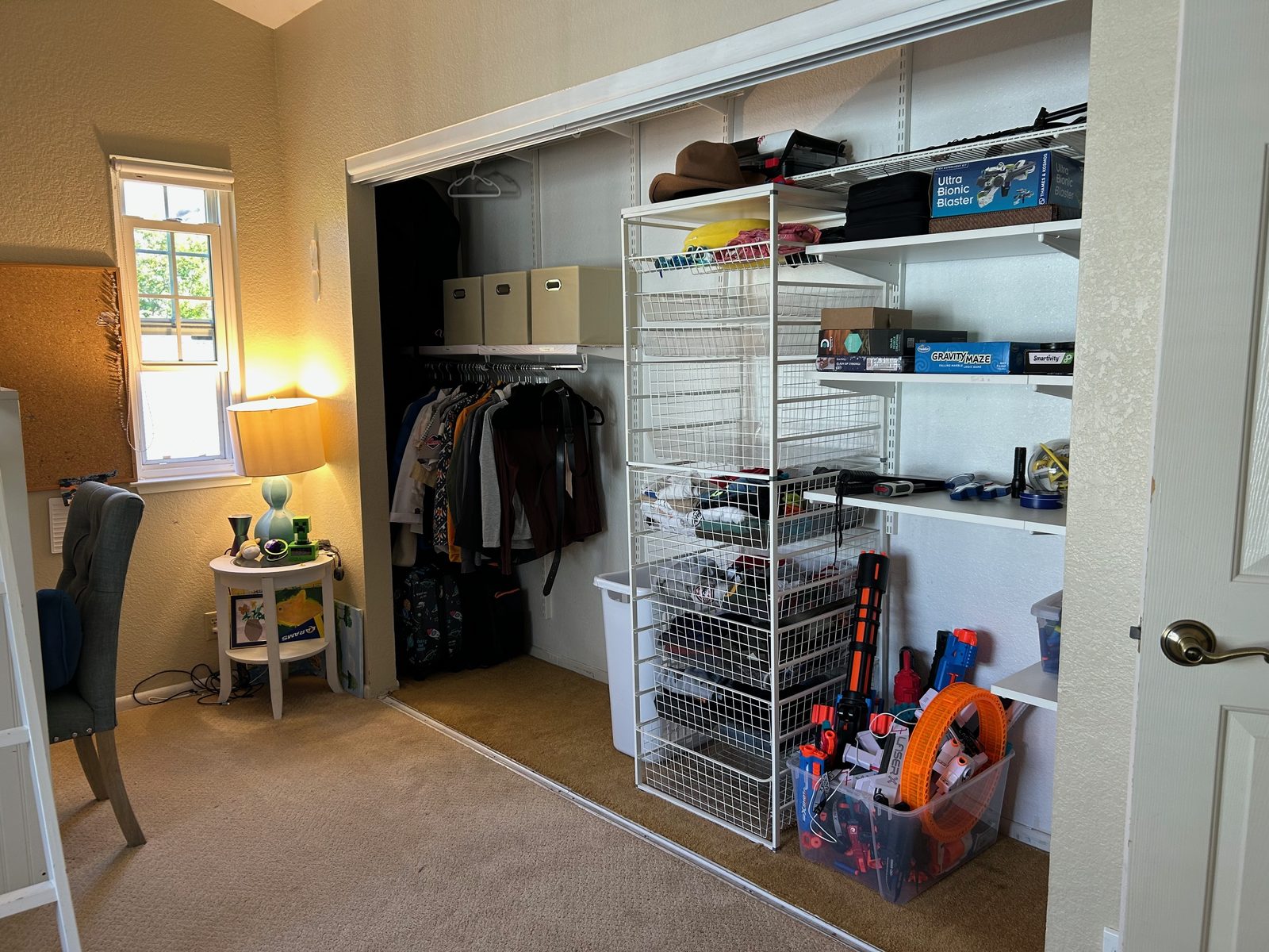 Bedroom closet after — clothes hung, toys sorted into drawers and shelves