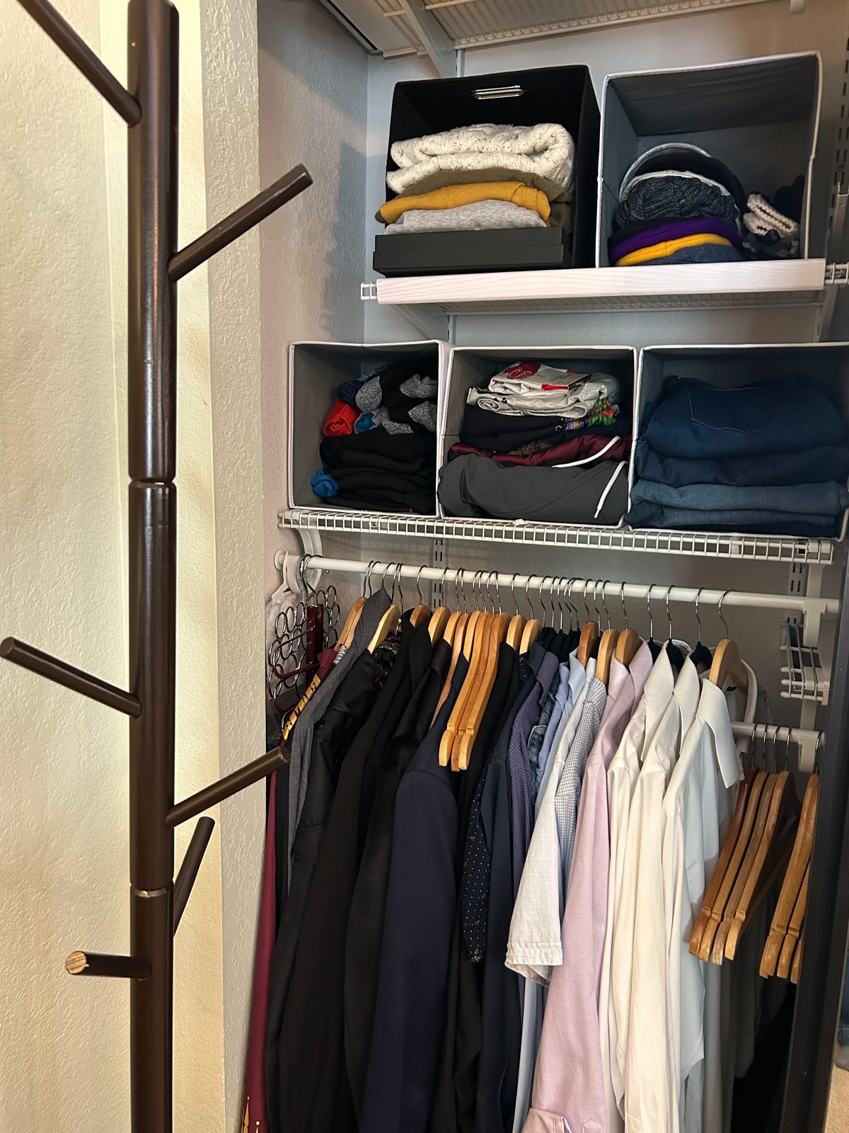 Closet after — sweaters folded into fabric bins, shirts on matching hangers