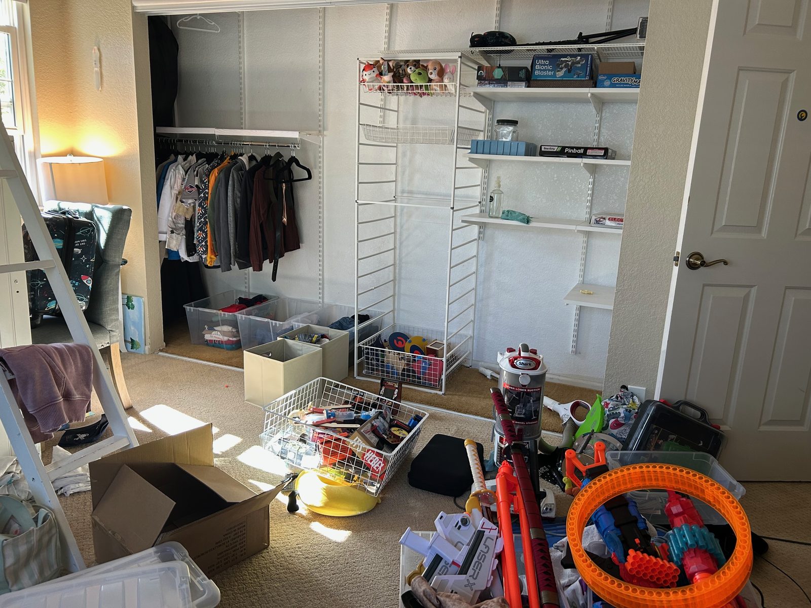 Bedroom closet before — toys and storage bins spilling out across the floor