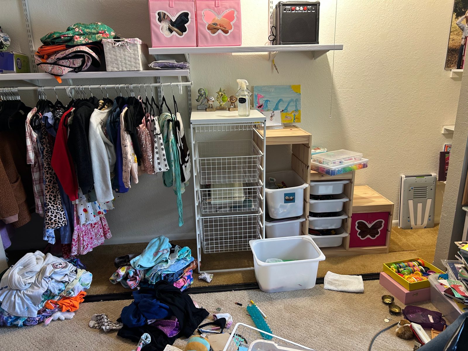 Closet play nook before — clothes and toys scattered across the floor
